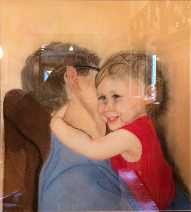 A smiling toddler wrapped in a warm hug.