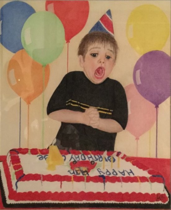 A boy in a party hat blowing out the candles on his birthday cake, surrounded by balloons.